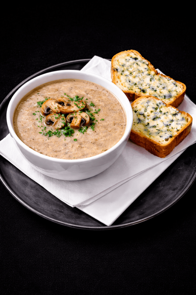 Supă cremă de ciuperci, servită cu pâine prăjită și brânză cu mucegai albastru